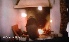 Grandmother at the fireplace of the house in Torricella